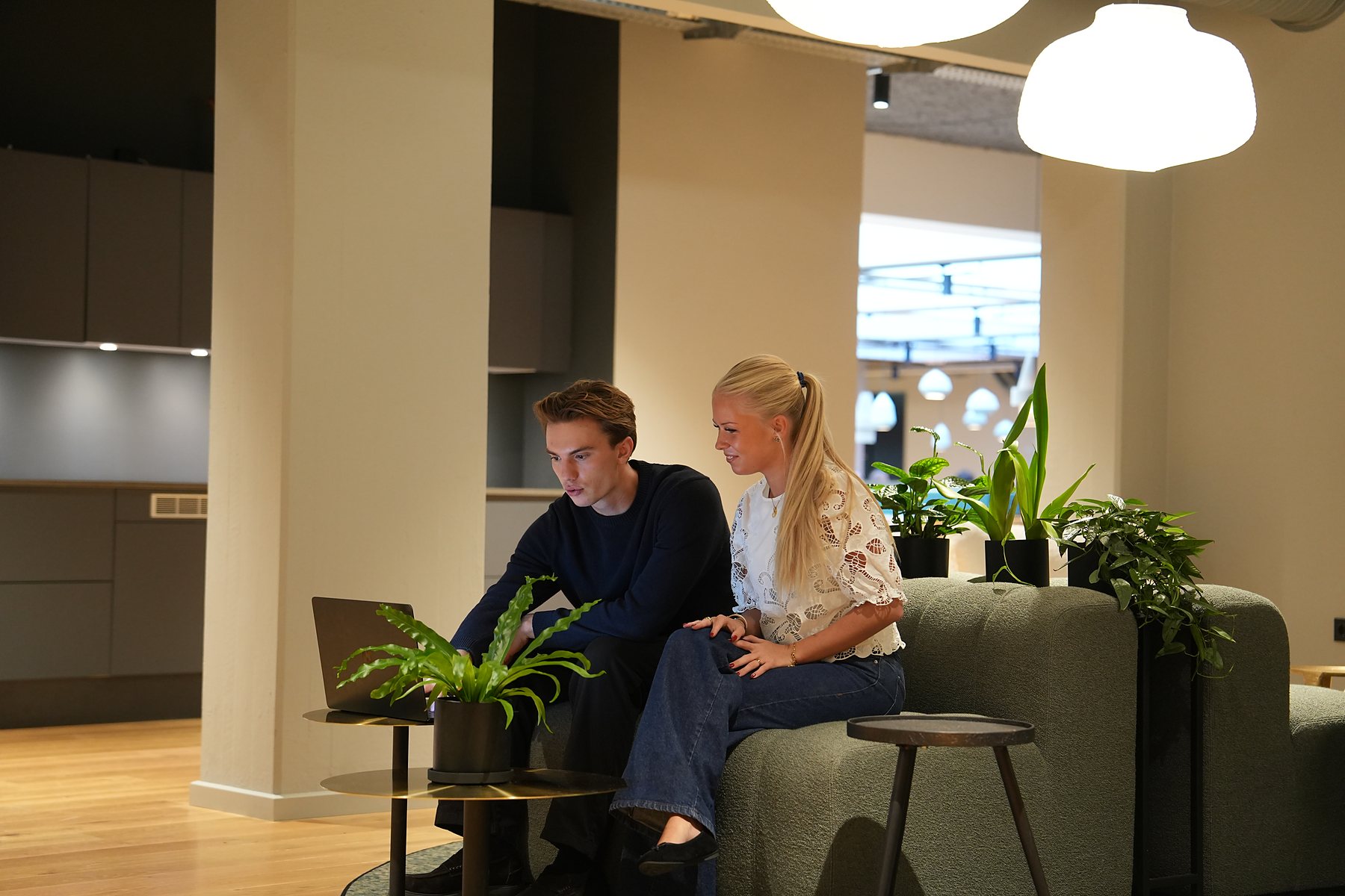 Two colleagues on the lounge sofa with a laptop