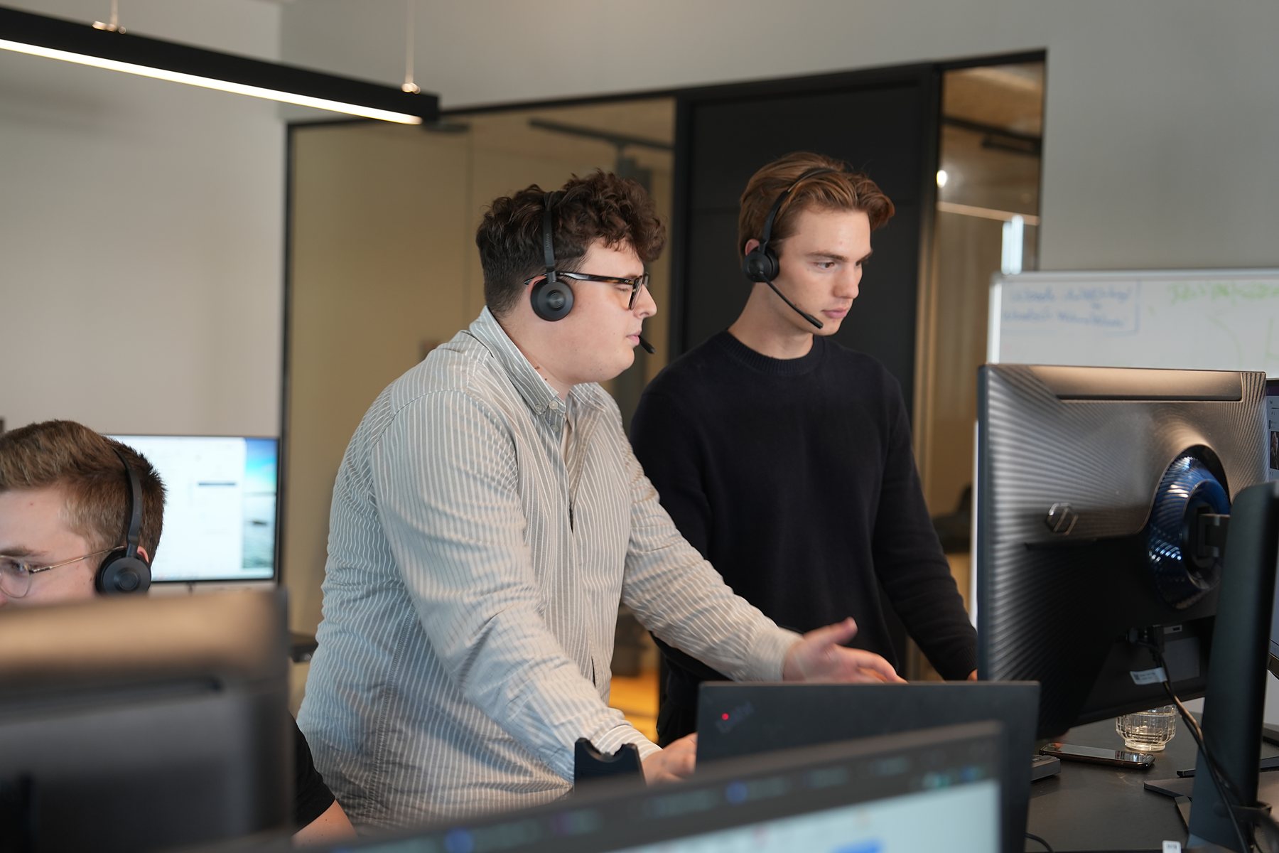 Two SDRs in headsets going through the same screen, one standing