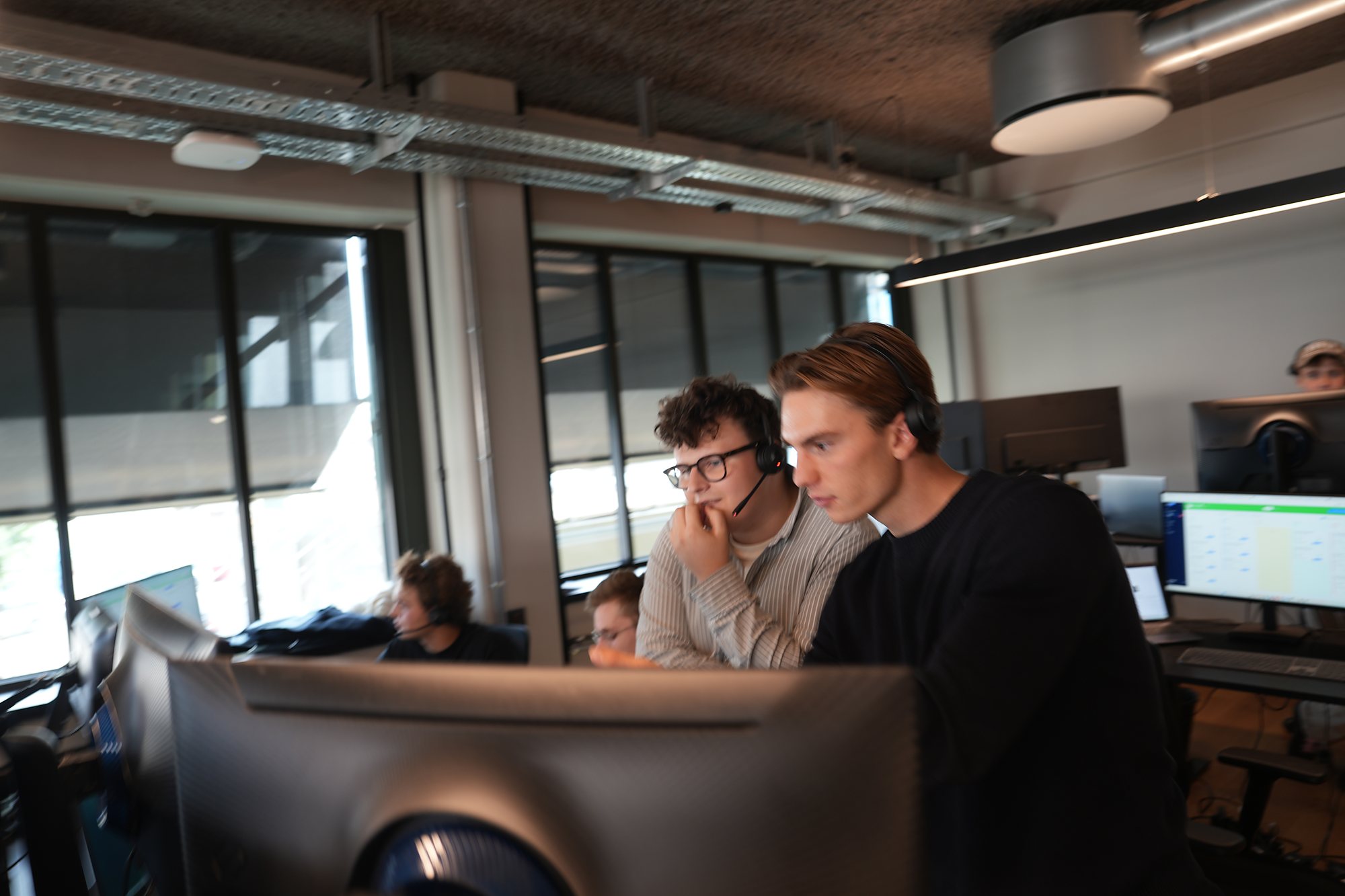 Two colleagues going through numbers on the same screen in the office
