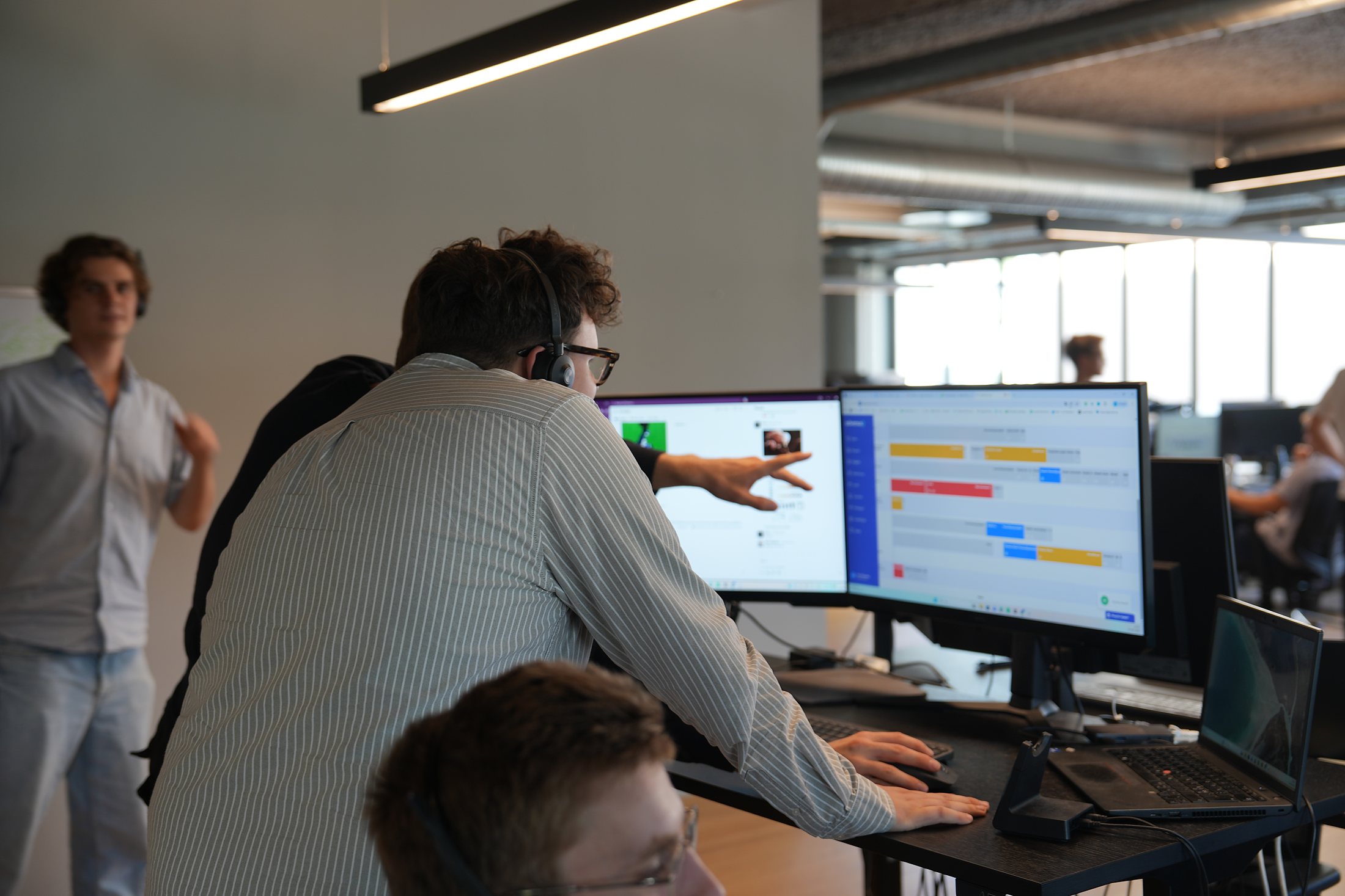 En kollega peger på kalenderen på skærmen for en SDR med headset