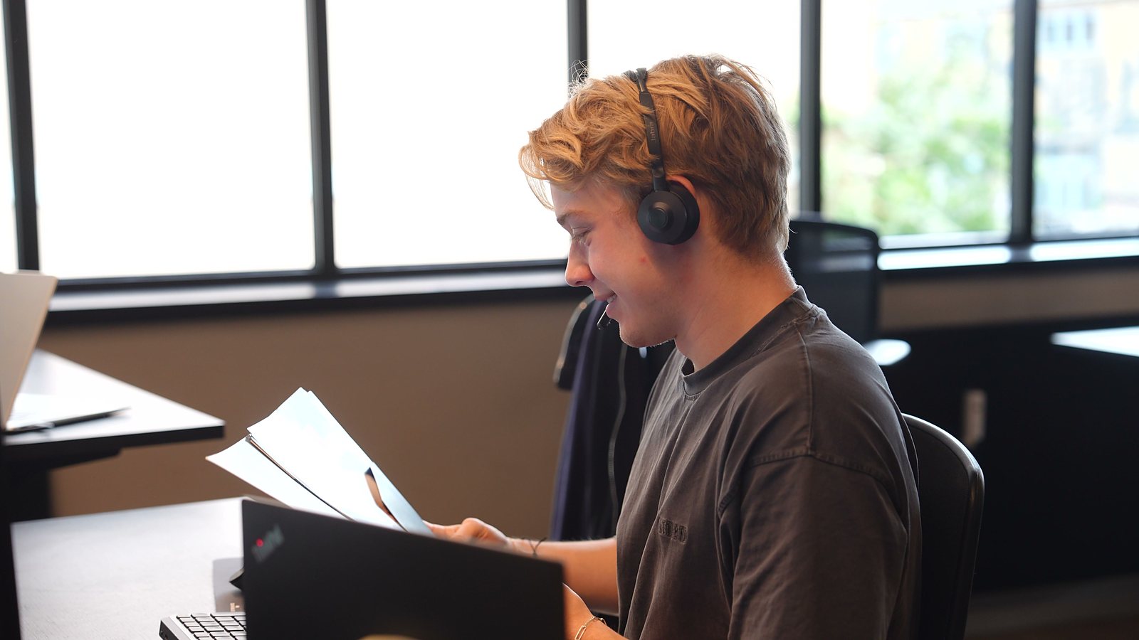 An SDR smiling down at a sheet of paper mid-call