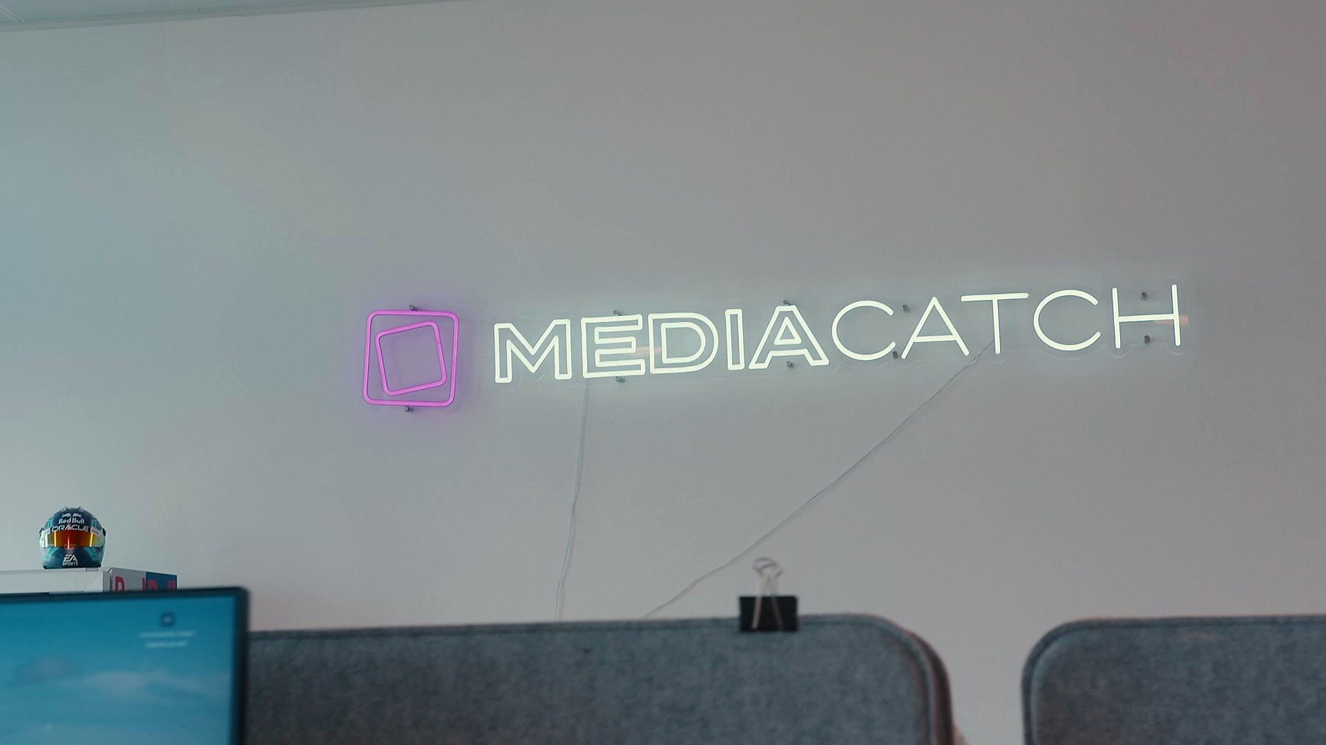 MediaCatchs neonlogo på kontorvæggen