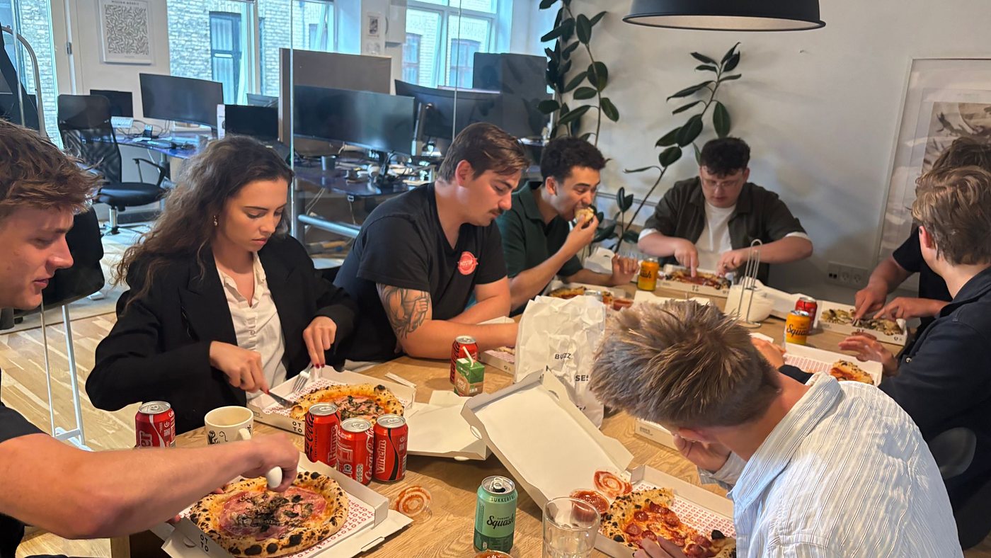 Arkivfoto: holdet omkring pizza på kontoret, 2024