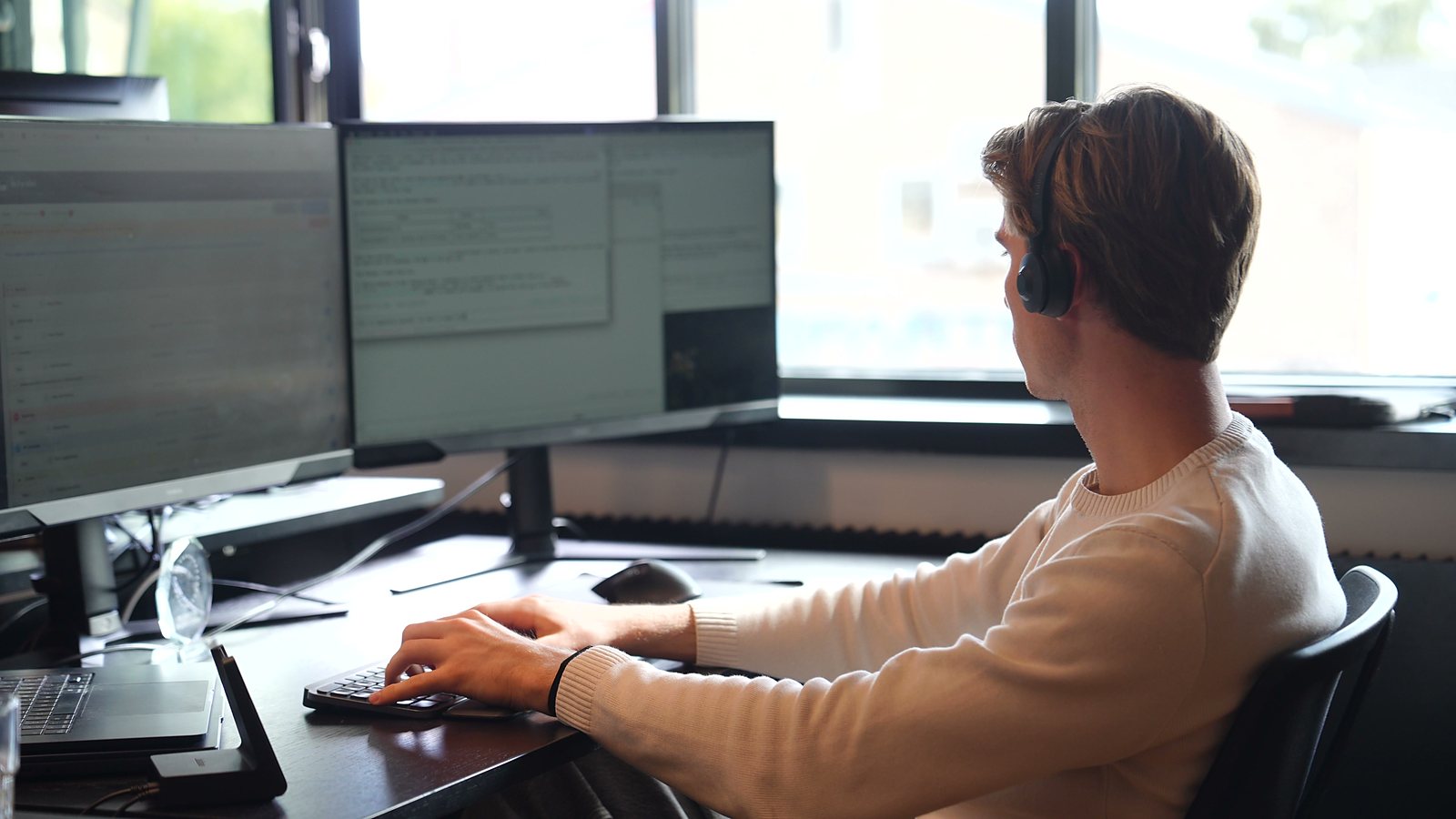 An SDR in a cream jumper typing at the keyboard